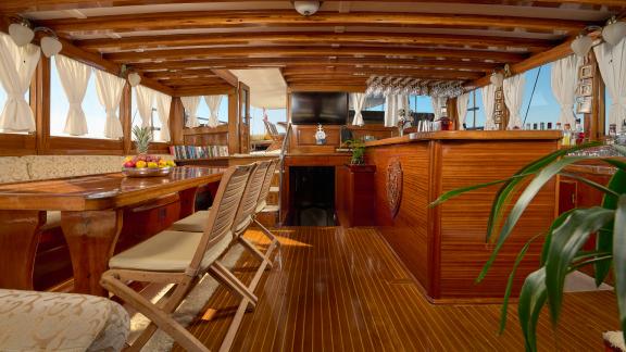 A cozy lounge with a bar on the gulet Linda. You can see the TV and a sofa